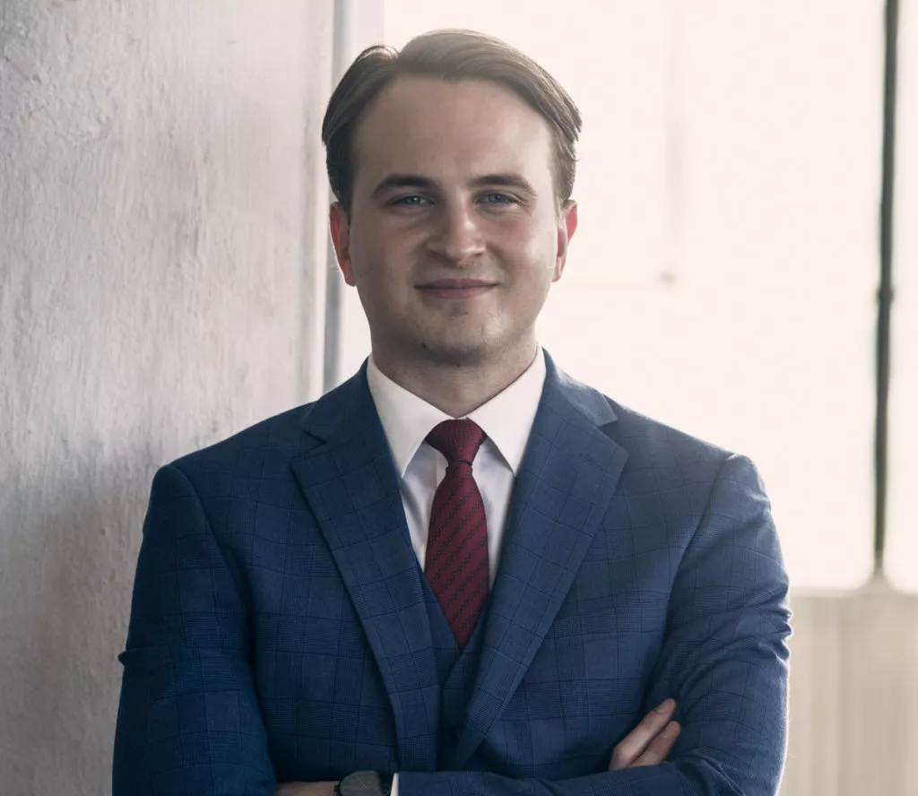 man smiling with arms folded